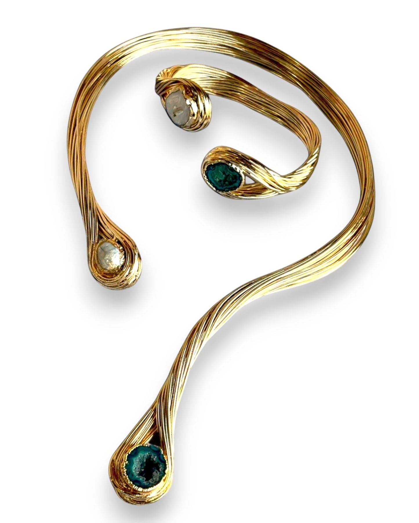 a close up of a gold bracelet with a green stone