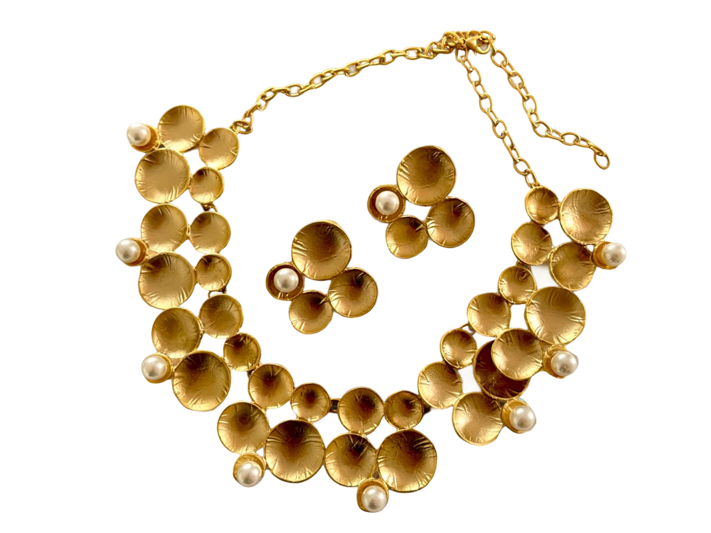 a gold necklace and earrings with pearls on a black background