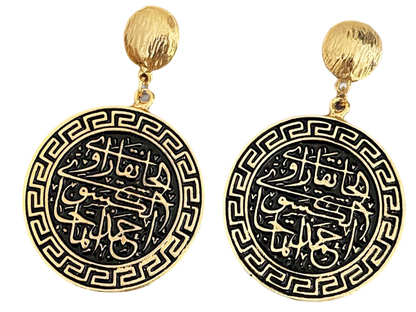 a pair of gold and black earrings with arabic writing