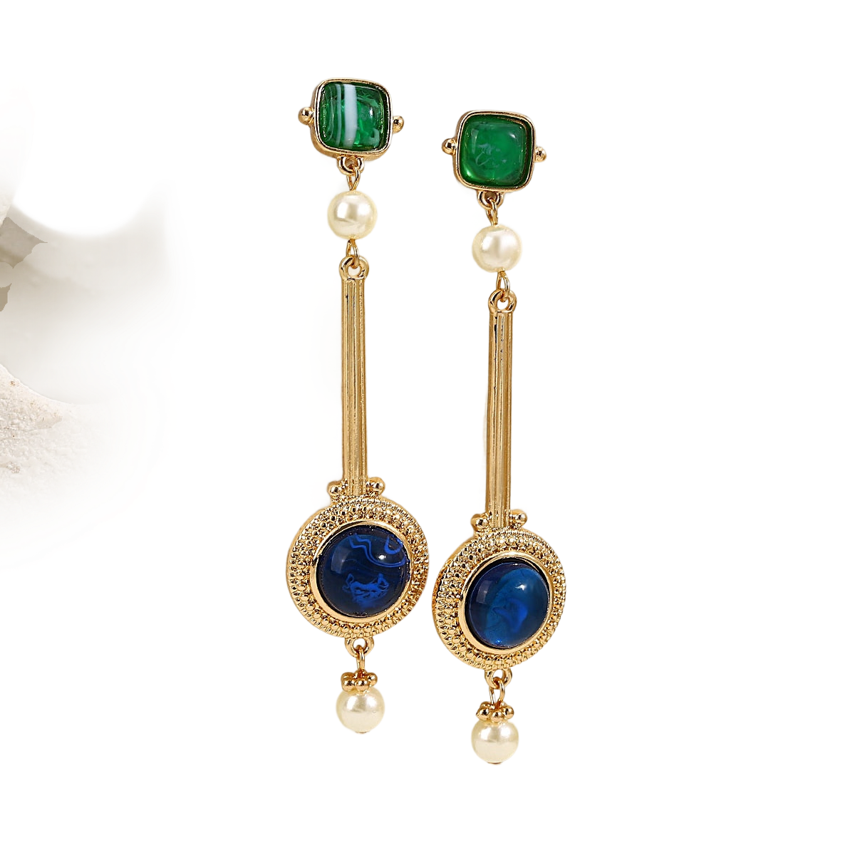 a pair of earrings with pearls and emeralds