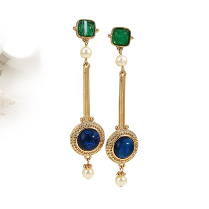 a pair of earrings with pearls and emeralds