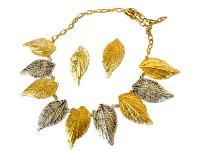 a gold and silver necklace with leaves on it