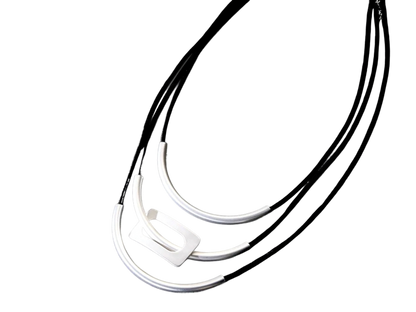 a black and white photo of three necklaces