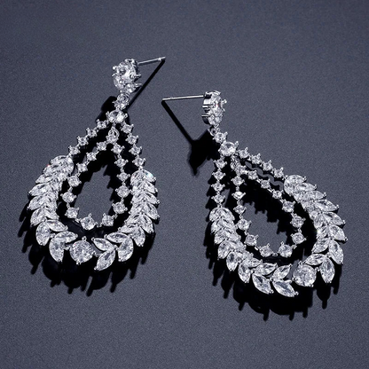 a pair of diamond earrings on a black background