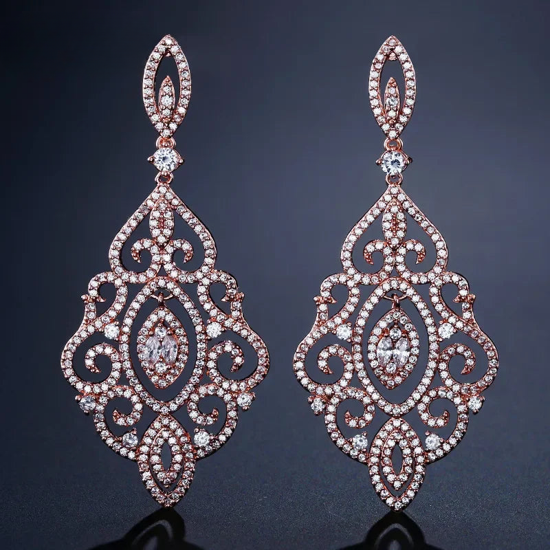 a pair of diamond earrings on a black surface