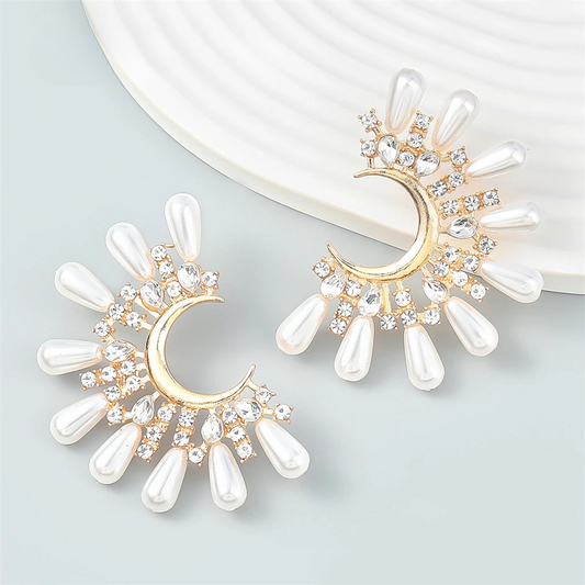 a pair of white and gold earrings