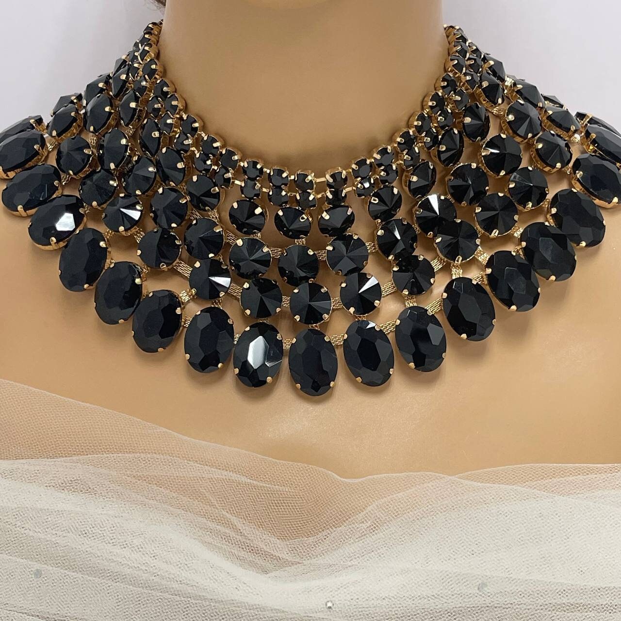 a black and gold necklace on a mannequin