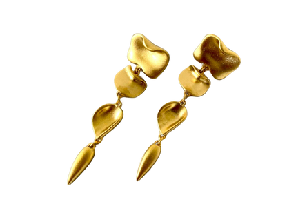 a pair of gold earrings on a black background