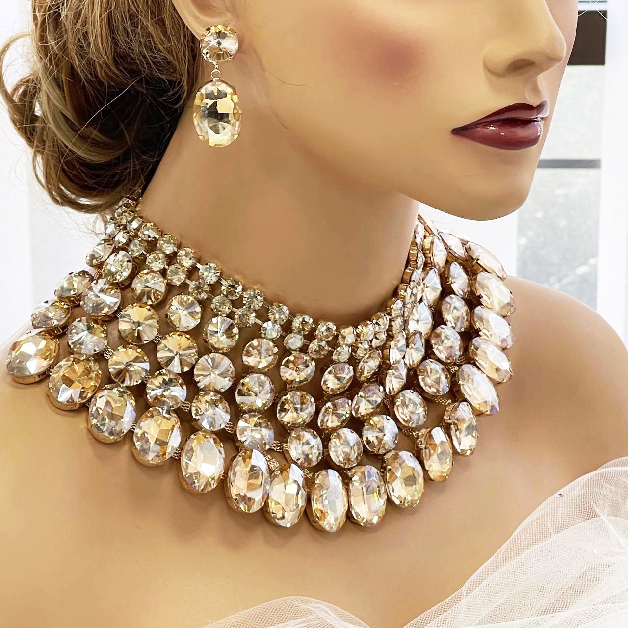 a close up of a mannequin wearing a necklace and earrings