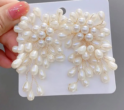 a hand holding a pair of white pearls