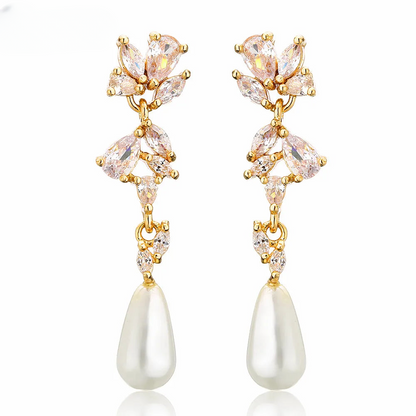 a pair of earrings with pearls and crystals