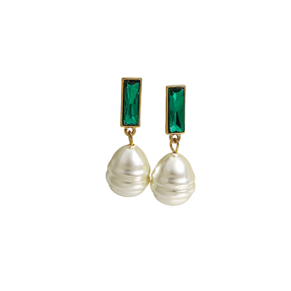 a pair of earrings with pearls and a green stone