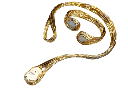 a gold necklace with a white stone on it