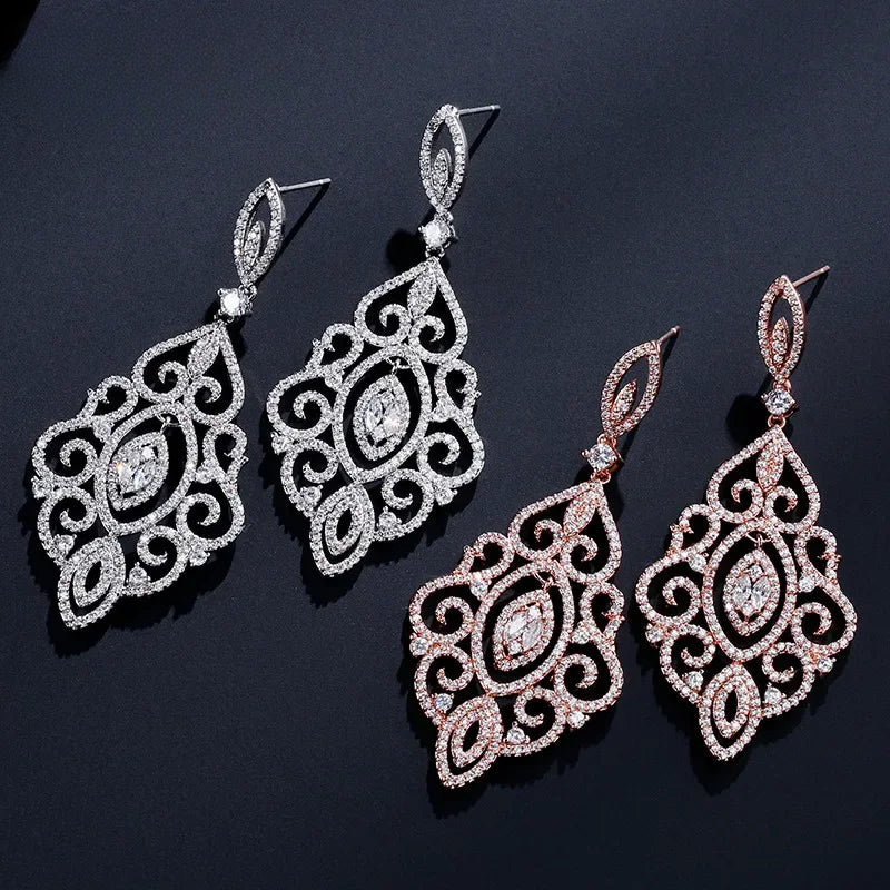 three pairs of earrings on a black surface