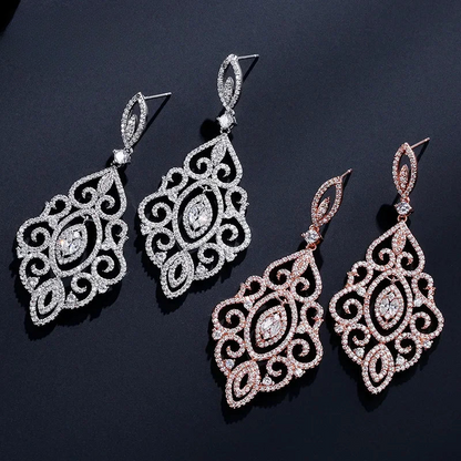 three pairs of earrings on a black surface