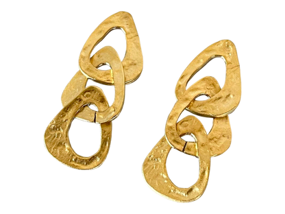 a pair of gold earrings on a black background