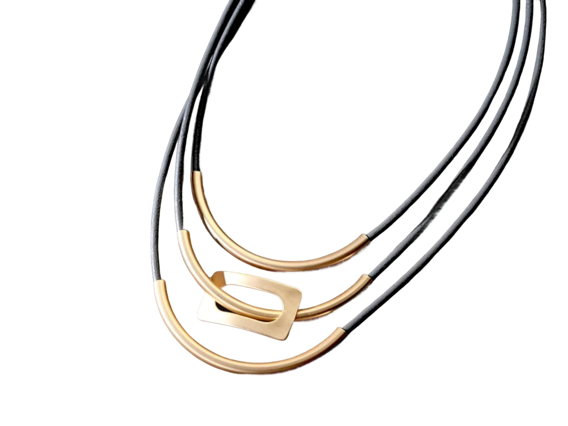 three black and gold necklaces on a black background