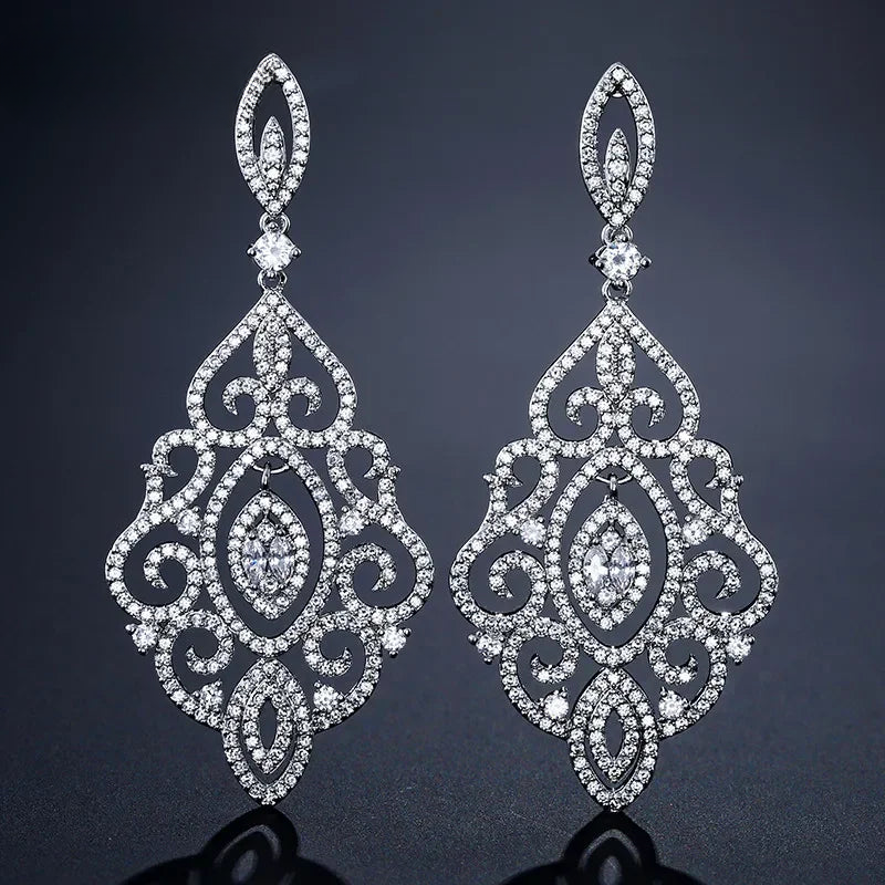 a pair of diamond earrings on a black background