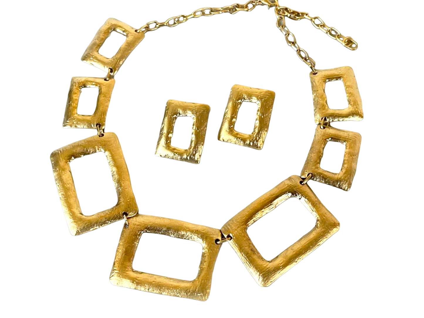 a gold necklace and matching earrings on a black background