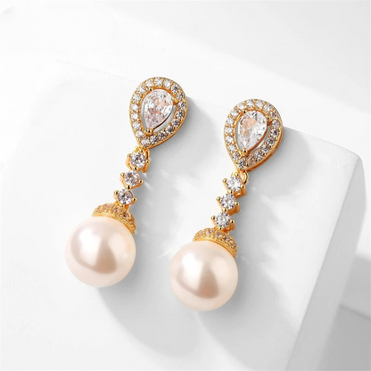 a pair of pearl and diamond earrings