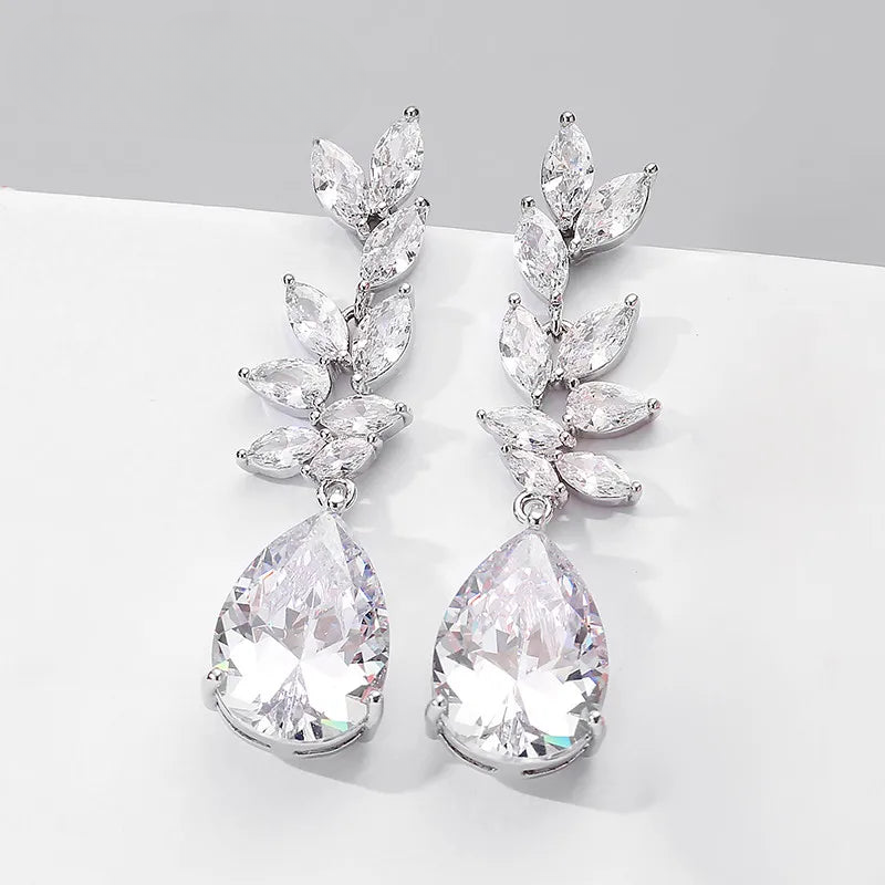 a pair of white crystal earrings on a white surface