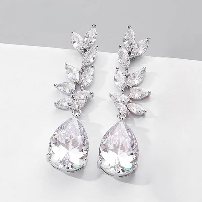 a pair of white crystal earrings on a white surface