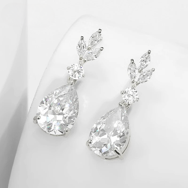 a pair of diamond earrings on a white surface