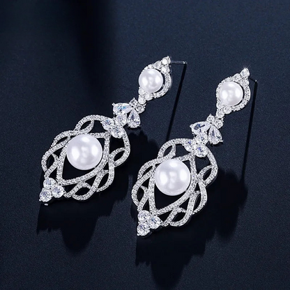 a pair of pearl and diamond earrings