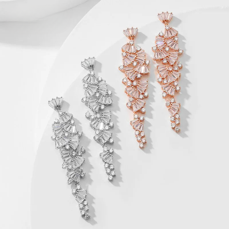 three pairs of earrings sitting on top of a white plate