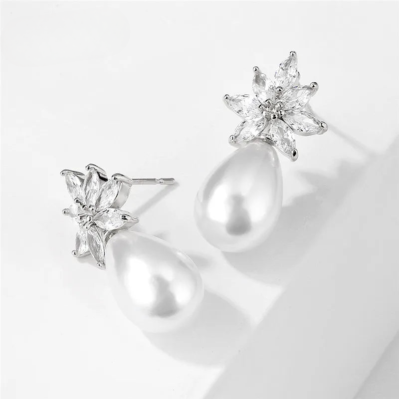 a pair of pearl and diamond earrings